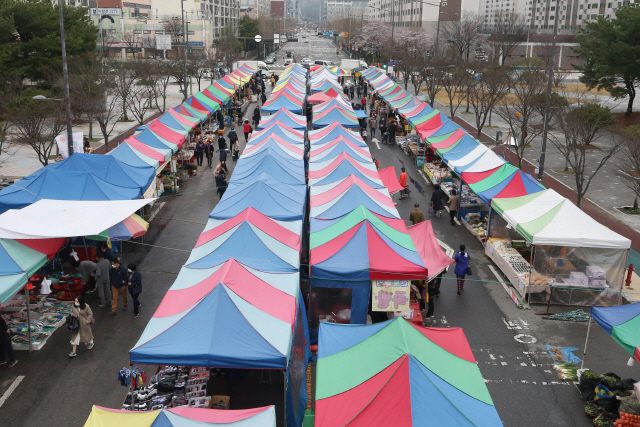 27일 오전 광주 서구 상무금요시장에서 코로나19 우려로 밀폐된 공간을 피해 식료품을 구입하려는 주민들의 발걸음이 이어지고 있다.  /광주=연합뉴스