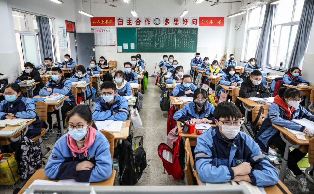 30일(현지시간) 중국 장쑤성 화이안의 한 중학교 교실에서 코로나19로 개학을 연기한 후 처음 등교한 학생들이 마스크를 쓴 채 긴장된 표정으로 수업을 하고 있다. /화이안=AFP연합뉴스