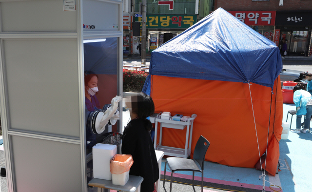 부산 남구보건소 안여현 의무사무관이 31일 오전 남구보건소 선별진료소에 마련된 ‘다목적 음압·양압 검체 채취 부스’에서 코로나19 진단 검사를 하고 있다. 이 부스는 안 사무관과 고려기연이 공동 개발했다./연합뉴스