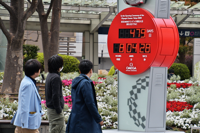 지난달 31일(현지시간) 일본 도쿄에 있는 롯폰기 힐스에서 시민들이 도쿄올림픽 개최까지 남은 날짜를 표시한 전광판 앞을 지나고 있다. /도쿄=UPI연합뉴스