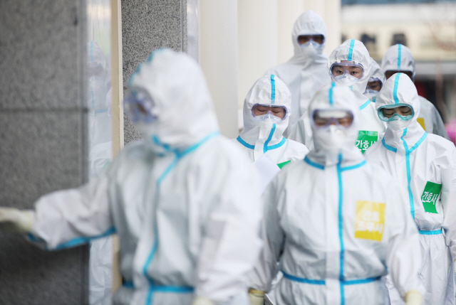 지난 31일 오전 대구시 중구 계명대학교 대구동산병원에서 마스크와 방호복을 착용한 의료진이 이동하고 있다./연합뉴스