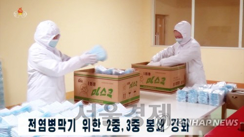 조선중앙TV가 지난 14일 방호복을 입고 마스크를 포장하는 북한 사람들을 보도하고 있다. /연합뉴스.