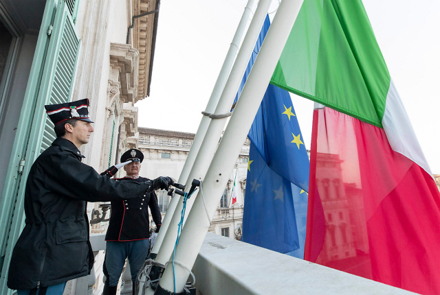 지난달 31일(현지시간) 이탈리아 대통령의 공식 관저인 로마 퀴리날레 궁전에서 코로나19 희생자들을 추모하기 위해 직원들이 유럽연합(EU)의 공식 깃발과 이탈리아 국기를 조기로 게양하고 있다. /로마=AFP연합뉴스