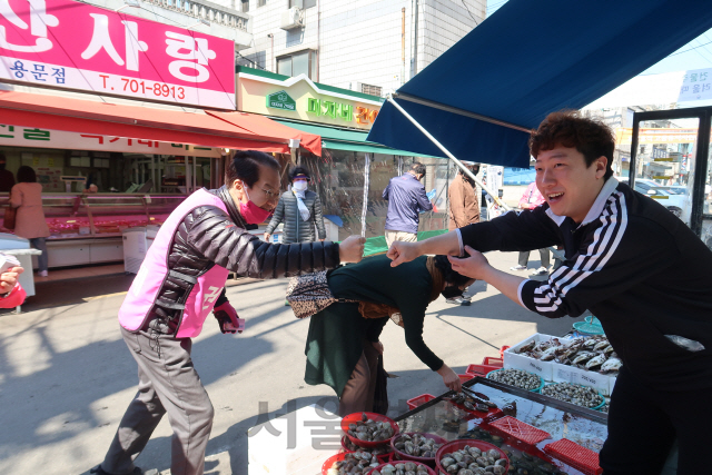 권영세 미래통합당 서울 용산 후보가 5일 서울 용문동 용문시장의 한 상점에서 유권자와 주먹을 맞대며 지지를 호소하고 있다. /진동영기자