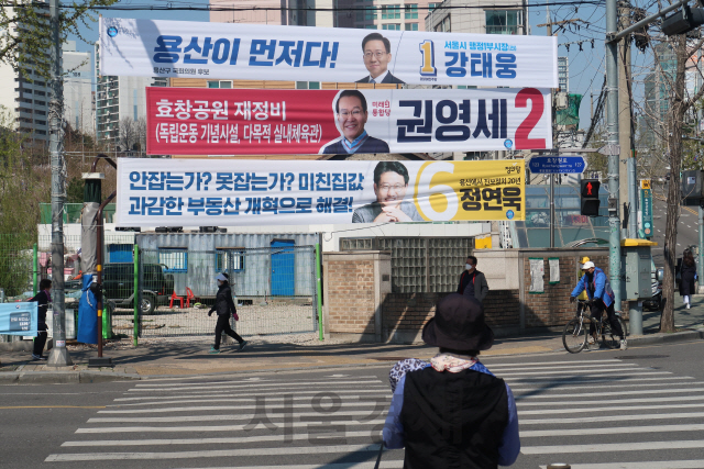 4·15 총선 공식선거운동 첫 주말을 맞은 5일 서울 용산구 용문동의 한 거리에서 시민들이 후보들의 선거홍보 현수막이 붙은 거리를 지나고 있다. /진동영기자