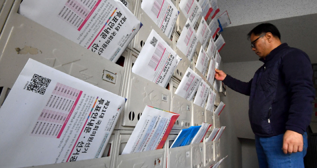 4·15 총선을 열흘 앞둔 5일 서울 마포구의 한 아파트에서 주민이 투표안내문과 선거공보물이 담긴 우편물을 수령하고 있다. 이날 행정안전부는 이번 총선 유권자 수는 총 4,399만4,247명으로 지난 20대 총선 때(4,210만398명)보다 189만3,849명(4.5%) 증가했다고 밝혔다. /권욱기자