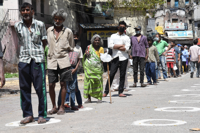 지난 3일(현지시간) 인도 뉴델리의 한 종교 시설 앞에서 사람들이 일정한 간격을 유지한 채 줄을 서서 음식 배급을 기다리고 있다./뉴델리=EPA연합뉴스