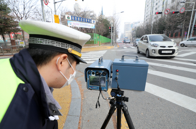 한 경찰관이 초등학교 앞 어린이보호구역(스쿨존)에서 과속차량을 단속하고 있다. /연합뉴스