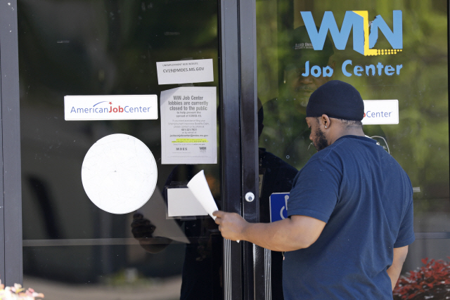 2일(현지시간) 미국 미시시피 주 노스잭슨에서 한 남성이 ‘WIN 잡 센터’의 유리문 앞에서 실업수당 신청서를 건네받고 있다. /노스잭슨=AP연합뉴스