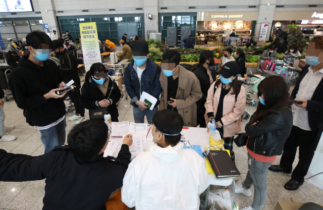 외국에서 국내로 들어오는 모든 입국자들에게 2주간 자가격리 의무화를 시작한 1일 오전 인천국제공항 1터미널에서 인천국제공항공사 직원과 각 시도 관계자들이 해외입국자 전용버스를 안내하고 있다./영종도=연합뉴스