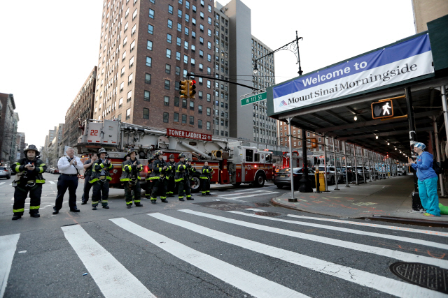 5일(현지시간) 미국 맨해튼의 마운트 시나이 모닝사이드병원 앞에 모인 소방관들이 병원 의료진에게 박수를 치며 경의를 표하고 있다. /뉴욕=EPA연합뉴스