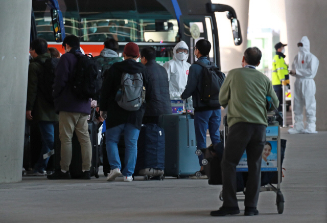이탈리아 교민과 주재원 등이 2일 오후 전세기를 타고 인천국제공항 2터미널을 통해 귀국해 버스에 오르고 있다./영종도=연합뉴스