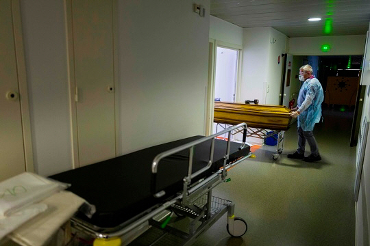 프랑스 뮐루즈의 한 병원에서 5일(현지시간) 마스크 쓴 장의사들이 신종 코로나바이러스 감염증(코로나19) 사망자의 시신이 안치된 관을 옮기고 있다. /AFP연합뉴스