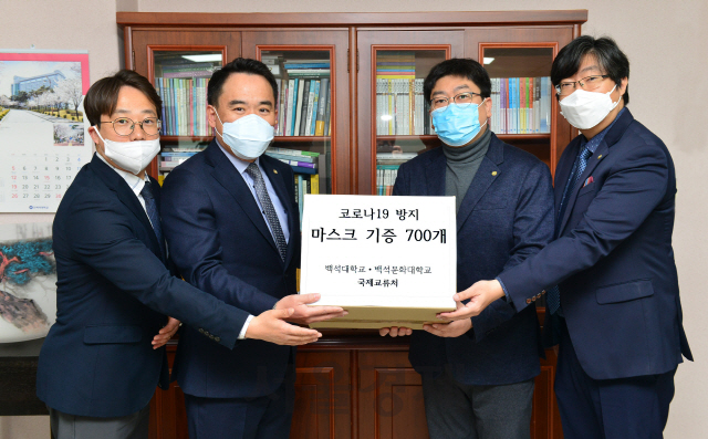 백석대 조운용(사진 왼쪽에서 세번째) 국제교류처장이 중국 교류대학에서 보내온 마스크를 백석대학교회 공규석(〃두번째) 담임목사에게 전달하고 있다. 사진제공=백석대