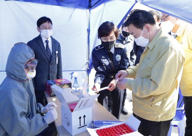 김오수 법무부 차관(오른쪽)이 31일 경기도 화성 소재 화성직업훈련교도소 선별진료소에서 코로나 진단키트를 살펴보고 있다. /연합뉴스