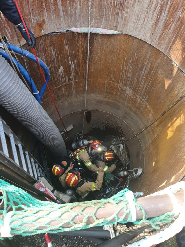 부산소방재난본부 119 구조대원이 사하구 하단동 하구도맨홀에서 가스 질식으로 쓰러진 작업자들을 구조하고 있다./사진제공=부산경찰청