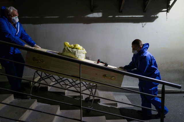 프랑스 동부 뮐루즈에서 지난 1일(현지시간) 방호복과 마스크를 착용한 장례회사 직원들이 신종 코로나바이러스 감염증(코로나19) 사망자의 시신이 안치된 관을 옮기고 있다. /뮐루즈=AFP연합뉴스