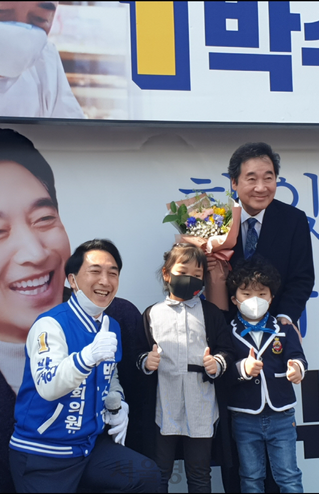 박수현 더불어민주당 공주·부여·청양 지역 후보가 10일 부여시장 앞에서 이낙연 전 국무총리와 함께 어린이들로부터 꽃다발을 받고있다.
