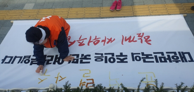 이은재 한국경제당 대표가 12일 서초동 대검찰청 앞에서 준비한 현수막 위에 손가락에 피를 내어 ‘윤석렬 사수’라고 적고 있다./사진제공=이은재대표측