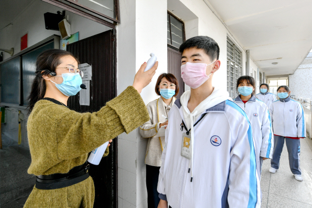 코로나19 확산에도 불구하고 중국 일부 지방에서 학교가 문을 연 가운데 저장성 후저우의 한 학교에서 체온 검사가 진행중이다. /신화연합뉴스