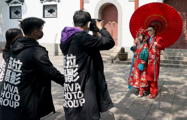 최근 ‘도시 봉쇄’가 해제된 후베이성 우한의 한 관광지에서 예비 부부가 지난 12일 웨딩사진을 찍고 있다. /신화연합뉴스