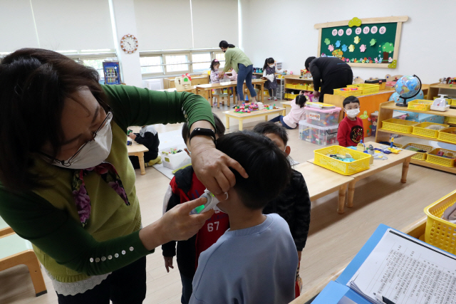 지난달 30일 광주 서구 광천초등학교병설유치원에서 긴급돌봄교실 교사가 원아 체온을 확인하고 있다. /광주=연합뉴스