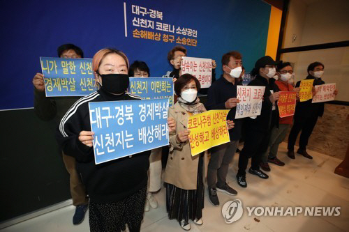 13일 오후 대구시 수성구 대흥동 대구 스타디움 몰에서 열린 대구·경북 신천지 코로나19 소상공인 손해배상 청구 기자회견에서 소송인단이 손 피켓을 들고 신천지에 피해 보상을 촉구하고 있다./연합뉴스