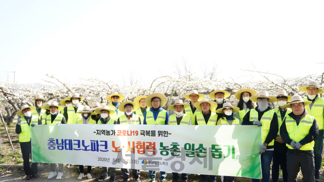 충남테크노파크 이응기 원장과 임직원 30여명이 코로나19 여파로 일손이 부족한 천안시 서북구 직산읍 배 농가를 대상으로 배꽃 화접 봉사활동을 벌이기에 앞서 기념촬영을 하고 있다. 사진제공=충남테크노파크