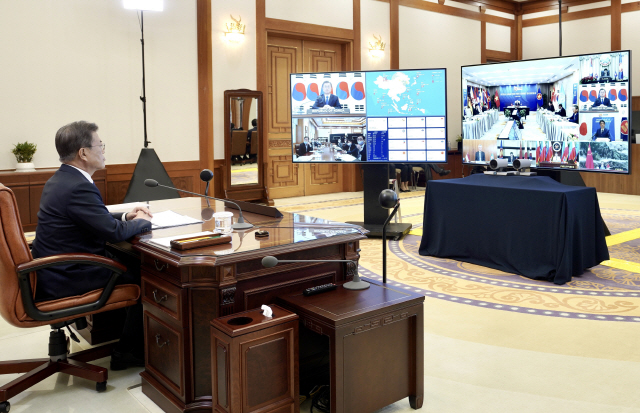 문재인 대통령이 14일 오후 청와대 집무실에서 ‘아세안+3 화상정상회의’를 하고 있다./연합뉴스