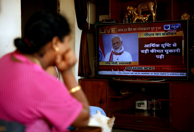 14일(현지시간) 인도 방갈로르에서 한 여성이 TV를 통해 나렌드라 모디 총리가 코로나19 확산에 따른 국가봉쇄령 연장 조치를 발표하는 것을 보고 있다. /방갈로르=EPA연합뉴스