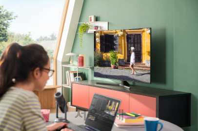 삼성 리모트 액세스 서비스를 통해 거실의 스마트TV와 노트북을 연결해 대형 화면으로 살피며 동영상 편집 작업을 하고 있는 모습./사진제공=삼성전자