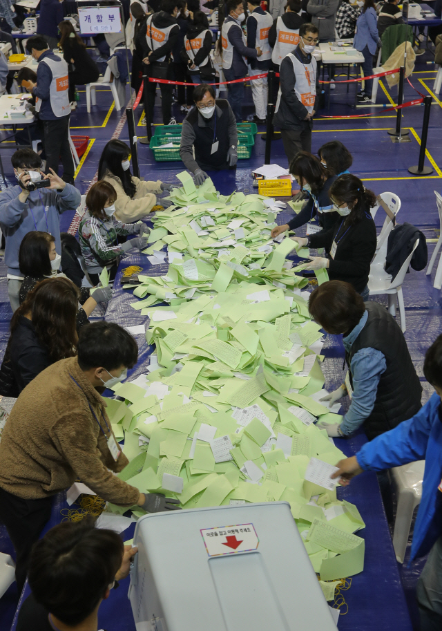 15일 오후 대전시 서구 괴정동 KT인재개발원에 마련된 서구개표소에서 개표종사자들이 국민들이 선택한 투표지를 투표함에서 꺼내고 있다./대전=연합뉴스