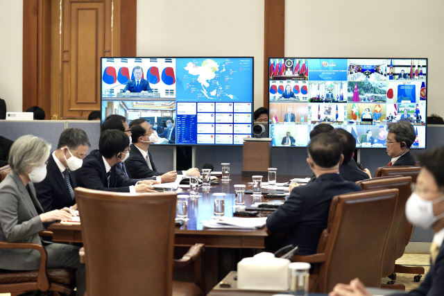 지난 14일 청와대 집무실에서 열린 코로나19 공동 대응을 위한 ‘아세안+3 특별 화상 정상회의’에서 정의용 국가안보실장, 강경화 외교부 장관을 비롯한 수행원들이 화상 정상회의를 지켜보고 있다. /연합뉴스