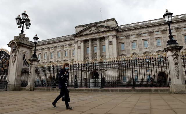 지난 2일(현지시간) 영국 런던에서 마스크를 쓴 여성이 버킹엄 궁전 앞을 지나가고 있다. /런던=AFP연합뉴스