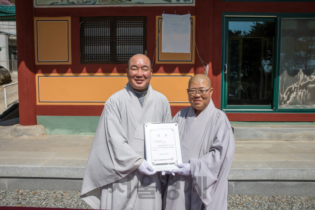 미타사 주지 희원스님(오른쪽)이 한국불교문화사업단 사무국장 우석스님(왼쪽)으로부터 템플스테이 운영사찰 증서를 수여받고 있다./사진제공=한국불교문화사업단