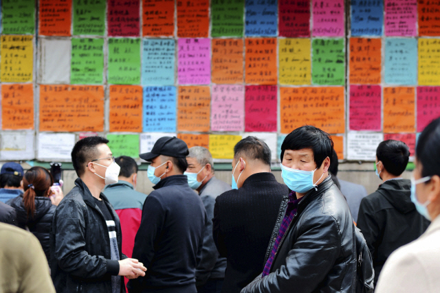 지난 8일 중국 산둥성 칭다오에서 구직자들이 직업소개소 안내판 앞에서 일거리를 찾고 있다. /AP연합뉴스