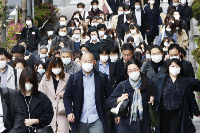 일본 도쿄의 한 거리에서 17일 마스크를 착용한 통근자들이 이동하고 있다. /도쿄= 교도AP연합뉴스