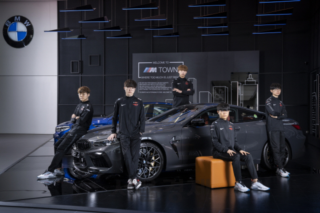 세계적인 e스포츠팀 T1 선수들이 BMW그룹이 팀 공식차량으로 제공한 차량들과 함께 포즈를 취하고 있다. /사진제공=BMW그룹