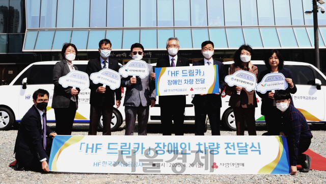 이정환(왼쪽 여섯번째) 한국주택금융공사장이 20일 부산 주택금융공사 본사 앞에서 신정택(〃 다섯번째) 부산사회복지공동모금회장에게 장애인 차량 3대를 전달하고 있다./사진제공=한국주택금융공사