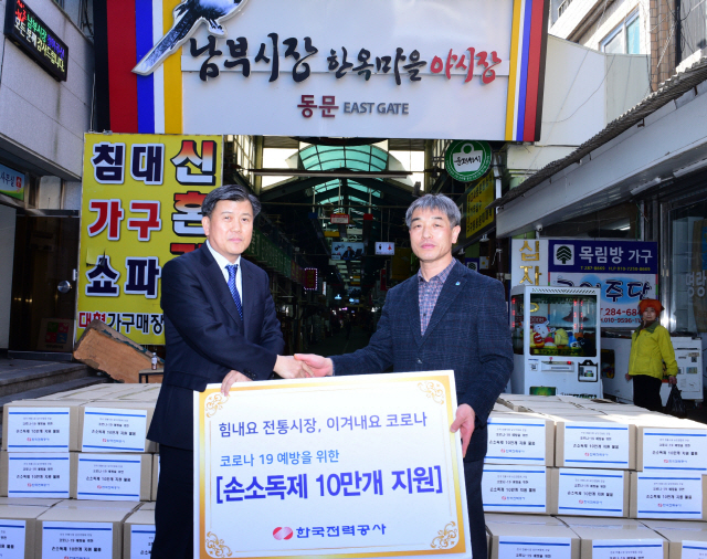 최영성(왼쪽) 한국전력 영업본부장이 하현수 전국상인연합회 회장에게 손소독제 10만개를 전달한 후 기념 촬영을 하고 있다./사진 = 한전 제공