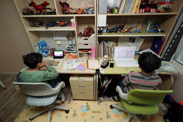 지난 20일 광주 남구 한 아파트에서 초등학교 1·3학년 형제가 온라인 개학을 맞아 노트북과 태블릿 PC로 수업을 듣고 있다./연합뉴스