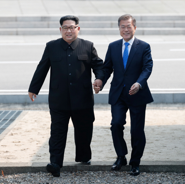2018 남북정상회담이에서 문재인 대통령과 김정은 북한 국무위원장이 함께 군사분계선(MDL)을 넘어오고 있다./사진=한국 공동 사진기자단