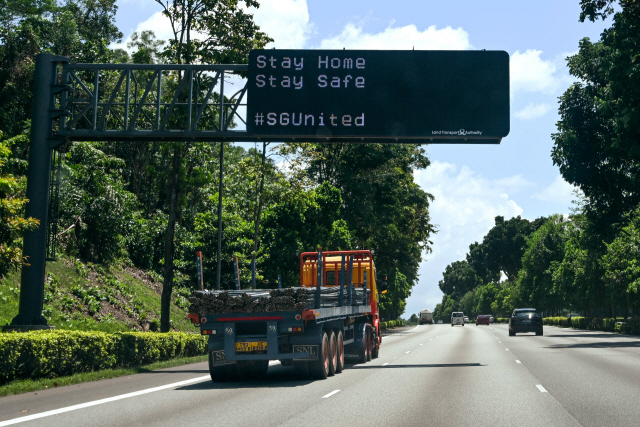 신종 코로나바이러스 감염증(코로나19)이 폭증하는 싱가포르의 고속도로 전광판에 19일 “집에 머물며 안전하게 지내라”(Stay Home Stay Safe)는 권고문이 표시돼 있다. /싱가포르=AFP연합뉴스