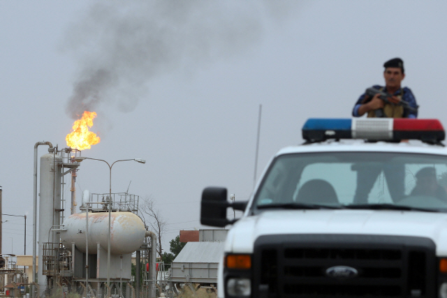 21일(현지시간) 엑손모빌, 로열더치셸 등 글로벌 메이저 석유회사들이 밀집해 있는 이라크 남부 바스라 유전지대를 총기를 든 경찰이 순찰하고 있다.　 /바스라=로이터연합뉴스