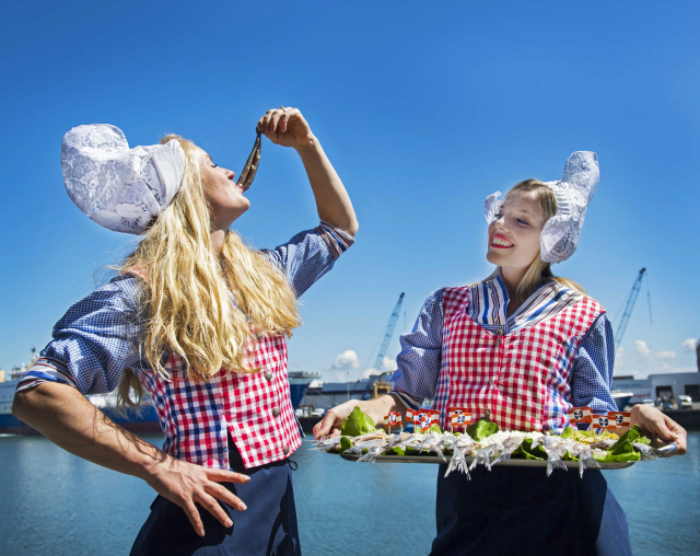 전통 의상을 입고 청어 요리를 시식하는 네덜란드 여성들./EPA연합뉴스