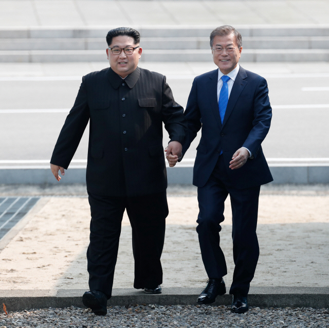 2018 남북정상회담이에서 문재인 대통령과 김정은 북한 국무위원장이 함께 군사분계선(MDL)을 넘어오고 있다./사진=한국 공동 사진기자단
