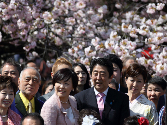 아베 신조 일본 총리가 지난 2014년 4월 12일 부인 아베 아키에 여사와 도쿄 신주쿠교엔에서 열린 ‘벚꽃을 보는 모임’에서 참석자들과 함께 사진을 찍기 위해 자세를 취하고 있다. /도쿄=블룸버그