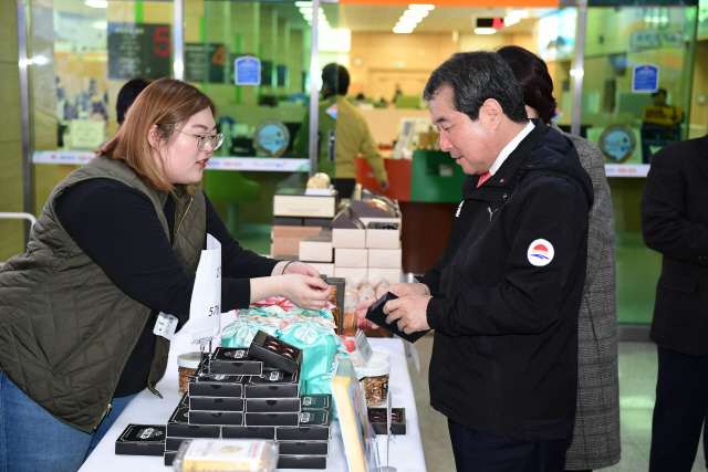 김충섭(오른쪽) 김천시장이 코로나19 피해 실태를 점검하기 위해 관내 상가를 방문해 물품을 구입하고 있다./사진제공=김천시