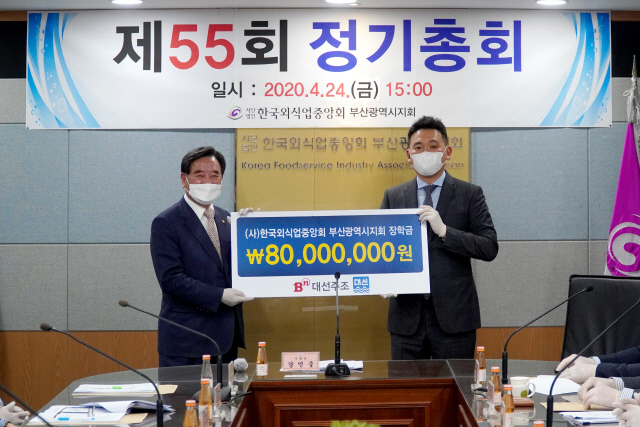 조우현(오른쪽) 대선주조 대표가 강인중 한국외식업중앙회 부산시지회장에게 지부회원 자녀들을 위한 장학금 8,000만 원을 전달했다./사진제공=대선주조