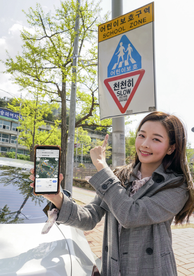 SK텔레콤 모델이 내비게이션 서비스 T맵에 새로 추가된 ‘어린이 보호경로’ 기능을 소개하고 있다. ‘민식이법’ 시행을 계기로 개발된 T맵 8.1버전은 이 기능을 통해 스쿨존을 우회하는 경로를 선택할 수 있는 옵션을 제공한다./사진제공=SK텔레콤